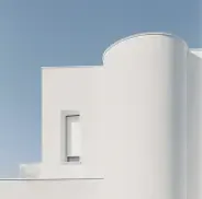 Minimalist white building with curved and straight rooflines.