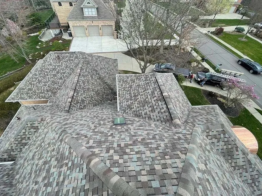 Finished asphalt shingle roof with multiple hips and valleys after a complete replacement.