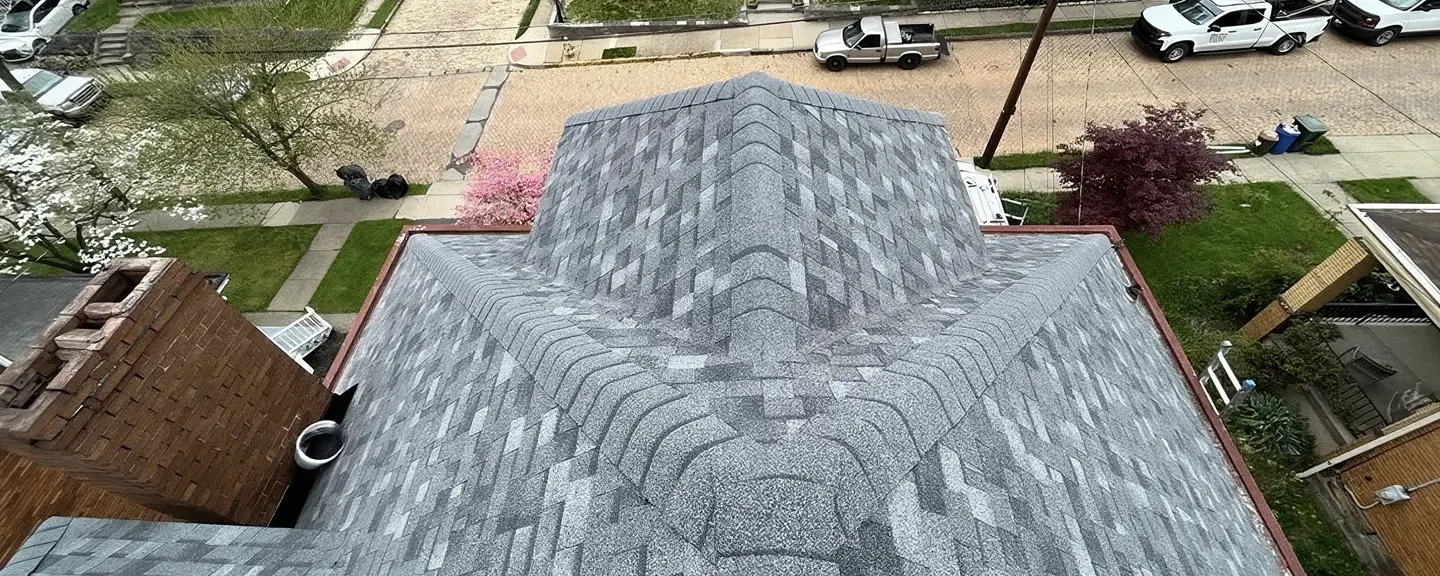 Aerial view of a finished gray architectural asphalt shingle hip roof on a brick colonial home in a Somerset County neighborhood.