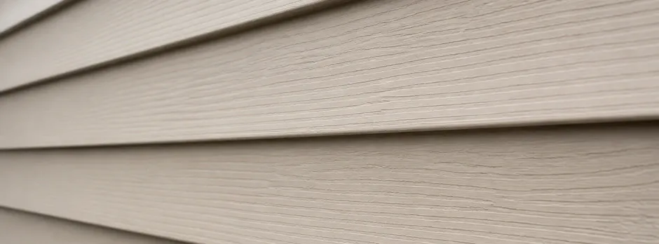 Close-up texture of well-maintained tan vinyl lap siding.