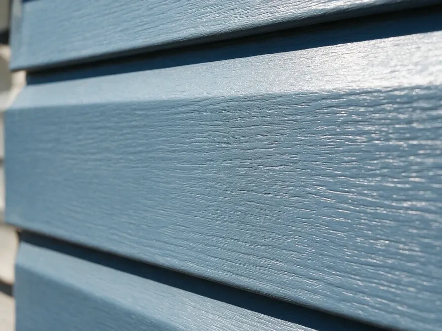 Close-up of a single blue-gray vinyl siding panel showing the interlocking edge detail.