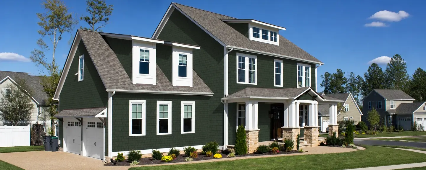Two-tone dark green and white American colonial home with brand new vinyl siding.